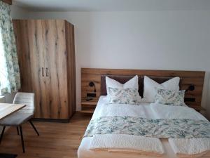 a bedroom with a large bed with a wooden headboard at Ferienhaus Gebetsberger in Spitz
