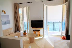 a living room with a couch and a tv at To Nisaki in Loutraki