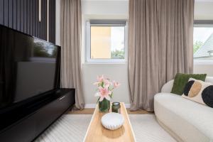 a living room with a couch and a tv at Aparthotel Cieplice in Jelenia Góra
