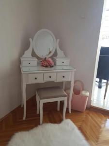 a white dressing table with a mirror and a stool at Apartmani Antunović Podgora in Podgora