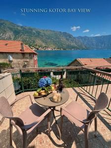 a table and chairs on a patio with a view of the water at Apartments Djurovic in Kotor