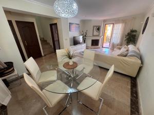 a living room with a glass table and white chairs at La Manga Atalayas in Atamaría