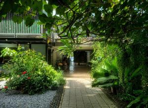 a garden with plants and a walkway in a building at Palmari Boutique Hotel in Ban Nua Khlong