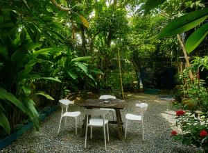 a table and chairs in the middle of a garden at Palmari Boutique Hotel in Ban Nua Khlong