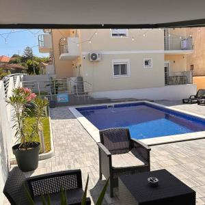 a swimming pool with two chairs and a house at Villa Ronić in Soko Banja +57 photos