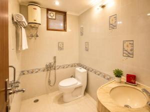 a bathroom with a toilet and a sink at Hotel Sunbeam in Gwalior