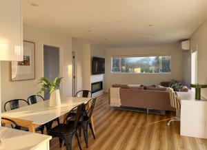 a living room with a table and a couch at Waikanae Beach Abode in Waikanae