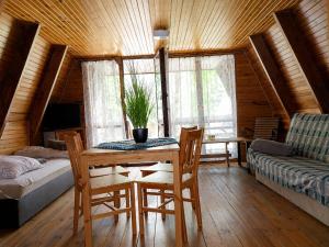 a room with a table and chairs and a bed at Osada Kujanki - domek wakacyjny in Zakrzewo
