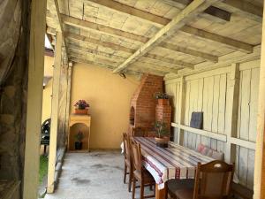 a patio with a wooden table and chairs and a brick at Vila dintre Brazi in Moieciu de Jos