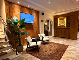 a lobby with two chairs and a tv on a wall at Hotel Bärenbachhof in Saalbach-Hinterglemm