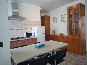 a kitchen with a table and a white refrigerator at APARTAMENTO SOL PLAYA in Punta Mujeres
