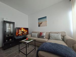 a living room with a couch and a fireplace at APARTAMENTO SOL PLAYA in Punta Mujeres