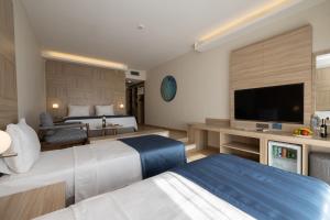 a hotel room with two beds and a flat screen tv at Azure By Yelken Hotel in Turgutreis +157 photos