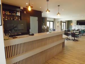 a bar in a restaurant with a dining room at The Originals City, Hôtel Le Gayant, Douai in Douai