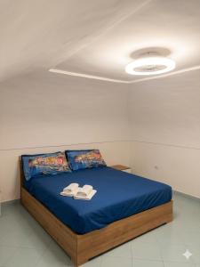 a bedroom with a blue bed with two white towels on it at Onda Blu House in Procida