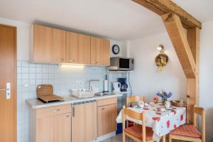 a small kitchen with a table and a table and chairs at Ferienwohnungen zur Eule - Steinkauz in Clausdorf