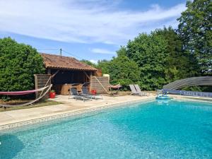 a house with a swimming pool and a hut at Domaine de la Bréssandière in Châtillon-sur-Thouet