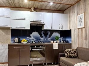 a kitchen with white cabinets and a stove at 2 Room central in Bălţi