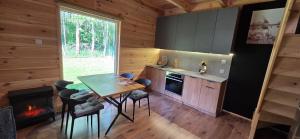 a kitchen with a table and chairs and a fireplace at Leśne Zacisze 4 in Łuka