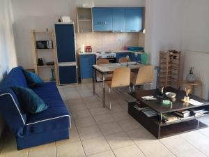 a living room with a blue couch and a table at Nova Ledeza NL in Igoumenitsa
