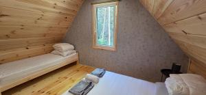 a small room with a bed and a window at Leśne Zacisze 4 in Łuka