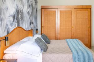 a bedroom with a bed with white sheets and pillows at Hotel Baia di Talamone in Talamone