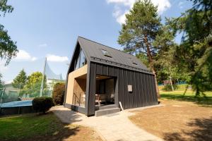 a small black house with a garage at Chalet - AQUA MARIA RESORT in Veľaty