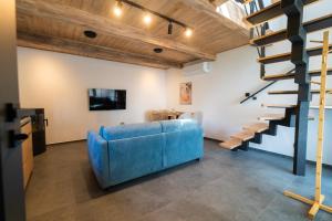 a living room with a blue couch and stairs at Chalet - AQUA MARIA RESORT in Veľaty