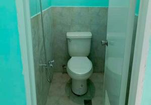 a small bathroom with a toilet in a stall at Monique Beach Resort by Hiverooms in Carmen