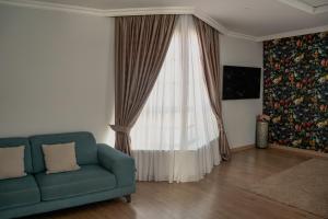 a living room with a blue couch and a window at Miramar Boutique Apartments ADULTS ONLY CORRALEJO in Corralejo