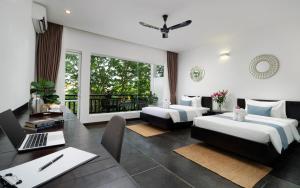 a bedroom with two beds and a desk with a laptop at Indochine Serenity Boutique in Siem Reap