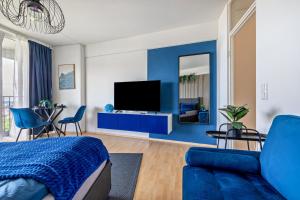 a bedroom with blue walls and a blue couch at Global Bnb - Loft 28 Blue in Augsburg