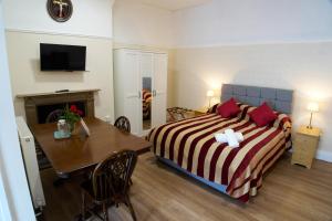 a hotel room with a bed and a dining table at St Winefride's Guesthouse in Holywell