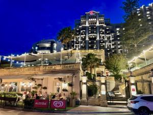 a building with people sitting outside of it at night at Simons Apartments minutes away from Balluta Bay and St Julians in Sliema