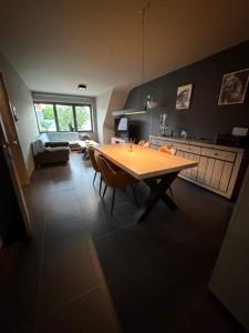 a kitchen with a wooden table and chairs in a room at Modern Duplex Apartment with terrace view in Stekene