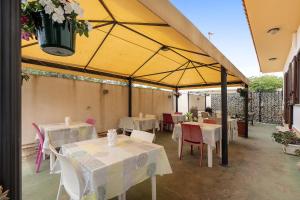 a restaurant with tables and chairs under a yellow umbrella at Demetra Malophoros in Marinella di Selinunte