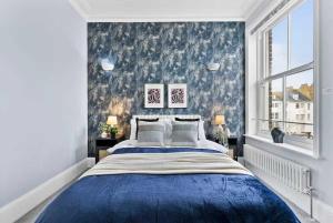 a bedroom with a blue bed and a window at Seafront Duplex Worthing Beach - Sea Views 8 Guests in Worthing
