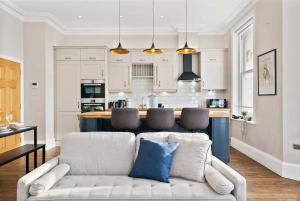 a living room with a couch and a kitchen at Seafront Duplex Worthing Beach - Sea Views 8 Guests in Worthing