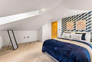 a bedroom with a large bed with a blue blanket at Seafront Duplex Worthing Beach - Sea Views 8 Guests in Worthing