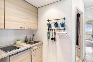 a kitchen with white walls and wooden cabinets at Global Bnb - Loft 28 Blue in Augsburg