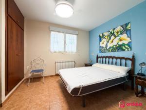 a bedroom with a bed and a painting on the wall at Udeville in Oropesa del Mar