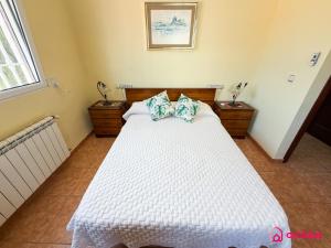 a bedroom with a white bed with two pillows at Udeville in Oropesa del Mar
