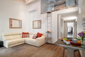 a living room with a white couch and a table at Conte Manfredo and Donna Angelina Apartments with Breathtaking Arena Views in Verona in Verona