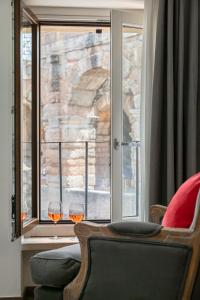 a room with two glasses of wine in a window at Conte Manfredo and Donna Angelina Apartments with Breathtaking Arena Views in Verona in Verona