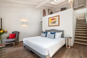 a bedroom with a white bed and a staircase at Conte Manfredo and Donna Angelina Apartments with Breathtaking Arena Views in Verona in Verona +36 photos