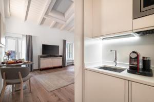 a kitchen and living room with a sink and a table at Conte Manfredo and Donna Angelina Apartments with Breathtaking Arena Views in Verona in Verona