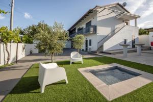 a yard with two white chairs and a pool at Olive Studios in Campo de Arca