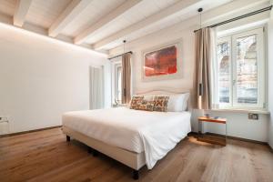a bedroom with a white bed and a window at Conte Manfredo and Donna Angelina Apartments with Breathtaking Arena Views in Verona in Verona
