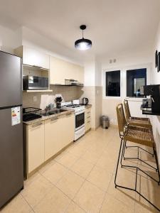 a kitchen with a refrigerator and a table and chairs at Paramont Rosario 4 in Rosario de la Frontera