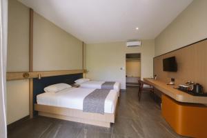 a hotel room with two beds and a desk at Legong Keraton Beach Hotel in Canggu +78 photos